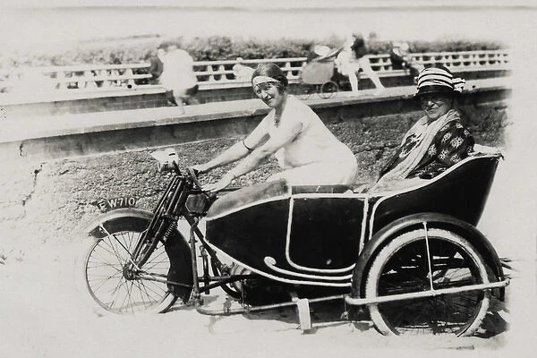 Two ladies on an early 1900s AJS motorcycle & sidecar