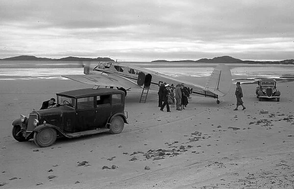 People on sandy beach with cars and light aircraft, Scotland