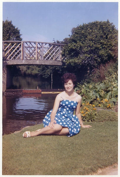 Pretty Young lady in a blue and white dress in a public park