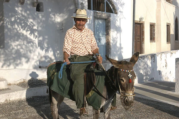 20064610. GREECE Cyclades Santorini Man on the back of a donkey in the street Thira