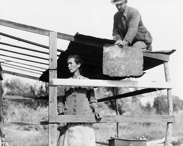 HOMELESS COUPLE, 1935. Dispossessed Arkansas farmers constructing a shelter