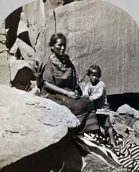 NAVAJOS, 1873. Navajo woman and her son at their home in Canyon de Chelly, Arizona