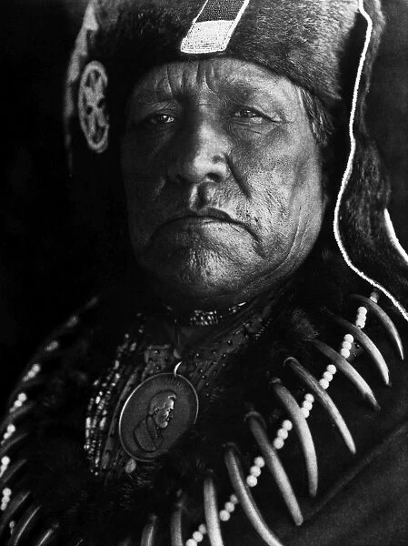OTO CHIEF, 1927. Old Eagle, an Oto chief from Oklahoma, wearing a bear claw necklace and a medal