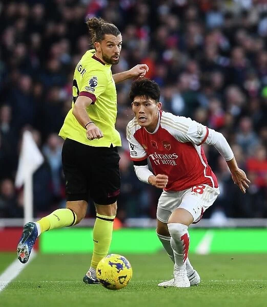 Arsenal's Tomiyasu Fends Off Burnley's Rodriguez in Premier League Clash