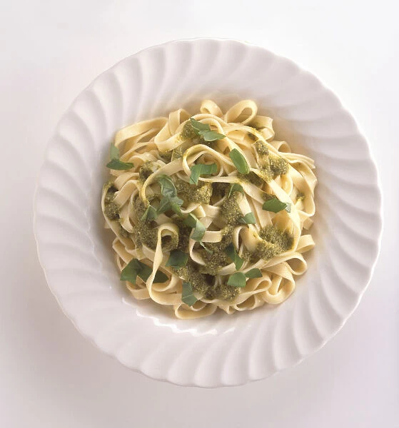 Trenette al pesto, trennette pasta with pesto sauce and basil leaves, a typical dish from Genoa, Liguria, Italy, view from above