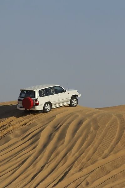 United Arab Emirates, Dubai, sports utility vehicle on top of sand tune