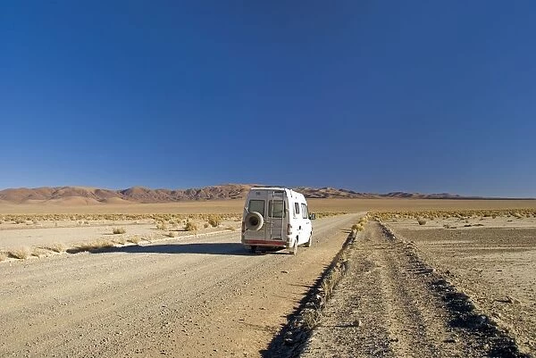 camper van on a desert road on the altiplano of argentina