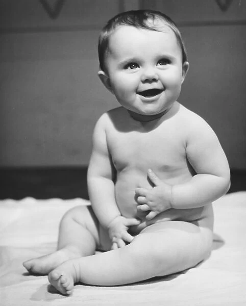 Naked baby boy (6-9 months) sitting on blanket (B&W)