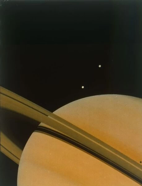 The planet Saturn with moons Tethys and Dione. Creator: NASA