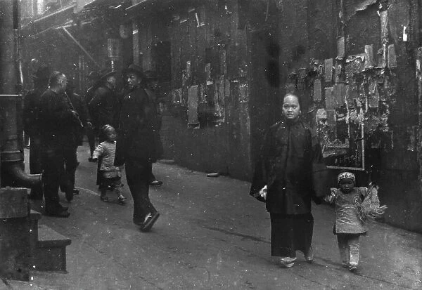 Woman and a child walking down a street, Chinatown, San Francisco, between 1896 and 1906. Creator: Arnold Genthe