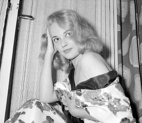 Actress Jeanne Moreau having her picture taken on a hotel bed July 1956