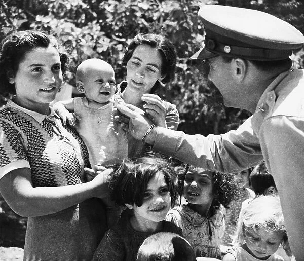 Allied soldiers meet Sicilian refugees during Second World War. 8th August 1943