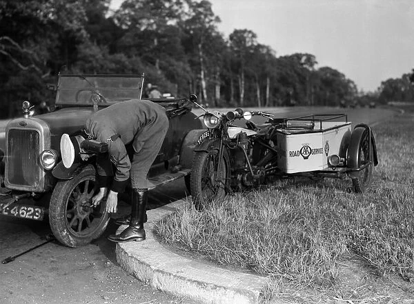 A Clyno car being repaired by an a patrol man. 1932