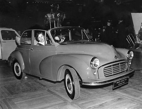 Pat Moss arrives in a Morris Minor 1000 Convertible, for a preview of the 1956 motor