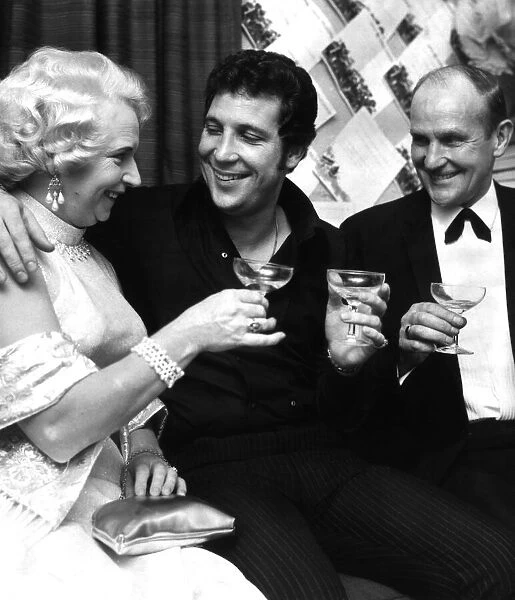 Singer Tom Jones with his parents drinking champagne in his dressing room on the night of
