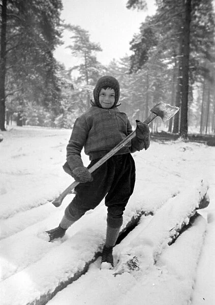 A young lumberjack at work in the snow Circa 1943
