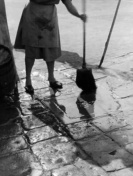 'Overflow!' woman cleaning the pavement with a broom