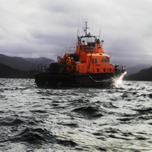 Mallaig severn class lifeboat Henry Alston Hewat 17-26. Lifeboat in the distance moving from left to right, hills and cliffs behind