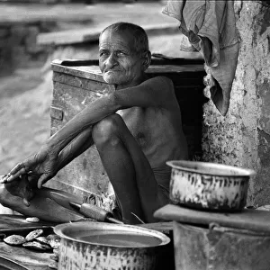 Indian man sits among his pots and pans, Old Delhi, India