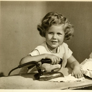 Little girl ironing her dolls clothes