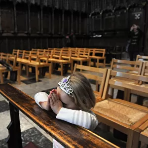 A little girl kneels to say her prayers - Carlisle Cathedral