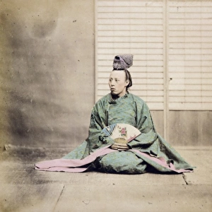 A man, possibly a government official, holding a fan, seated