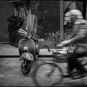 Moving figure on bike, motor scooter, Italy