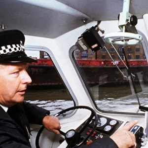 Policeman at the controls of a riverboat