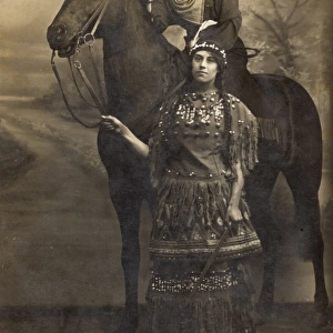 Two women in costume with horse in studio photo