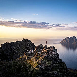 Person contemplating sunset from top of mountains, Senja island, Troms county, Norway