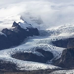 Tongue of the Vatnajokull Glacier creeping down the mountains behinf Fjallsarlon lagoon