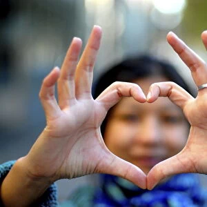 Woman making a heart with her fingers, Paris, France, Europe