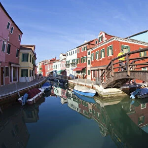 The many colours of the typical houses of Burano are reflected into the green waters