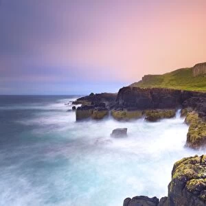 Rocky cliffs and sea, with wooden hills, Staffin bay, Isle of Skye, Scotland, UK