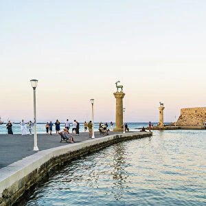 The statues of the Myth Colossus of Rhodes at the Mandraki Marina and Port looking towards Saint Nicholas Fortress, Rhodes Town, Rhodes, Dodecanese Islands, Greece