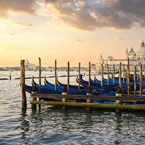 Sunrise in Venice with gondolas and Santa Maria della Salute church on the background