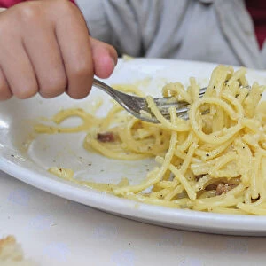 Italy, Lazio, Rome, child eating spaghetti carbonara