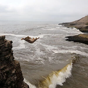 Fernando Jesus Canchari, dressed as a friar jumps from a 13-meter high cliff along