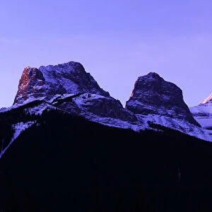 The first light of the day hits the Three Sisters Mountain range