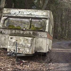 Caravan abandoned beside track at edge of woodland, Skane, Sweden