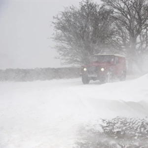 Land Rover travelling along rural road during severe snowstorm, A685, near Ravenstonedale, Cumbria, England, March