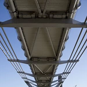 Underneath steel suspension footbridge crossing river, Millennium Bridge, River Thames, London, England, april