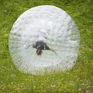 Zorbing, person rolling downhill in transparent plastic orb, Sweden, June