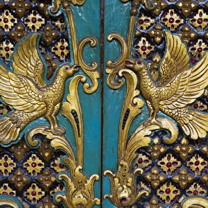 Asia, Indonesia, Bali. Gilded carved temple doors with symbols of birds in Bali