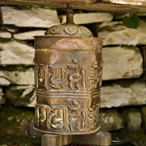 Nepal, Annapurna. Buddhist prayer wheel at a small temple along the trail to Ghandruk