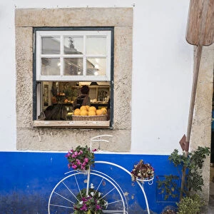 Portugal, Obidos. Cute bicycle planter in front of a bakery in the walled city of Obidos