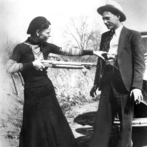 BONNIE AND CLYDE, 1933. American criminal Bonnie Parker (1911-1934) playing at holding up her partner, Clyde Barrow (1909-1934). Photographed in 1933