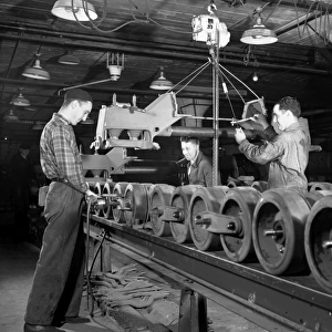 Men working on an assembly line to manufacture U. S. Army half-track scout cars in a converted truck plant in Ohio, during World War II. Photograph by Alfred Palmer, December 1941
