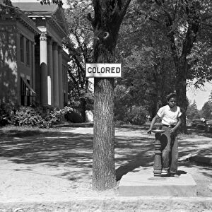 SEGREGATED FOUNTAIN, 1938. A boy drinking from a segregated water fountain on the