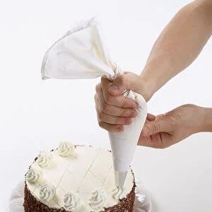 Cream rosettes being piped onto the top of a black forest cake
